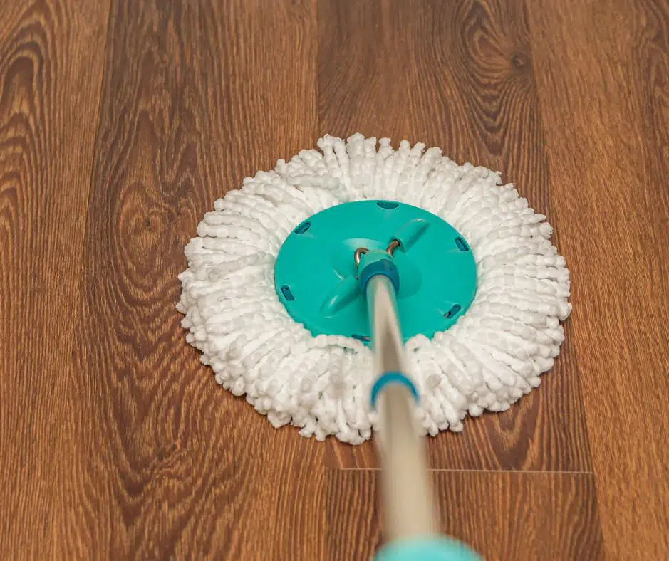 acqua coloured spin mop being used to clean vinyl plank flooring