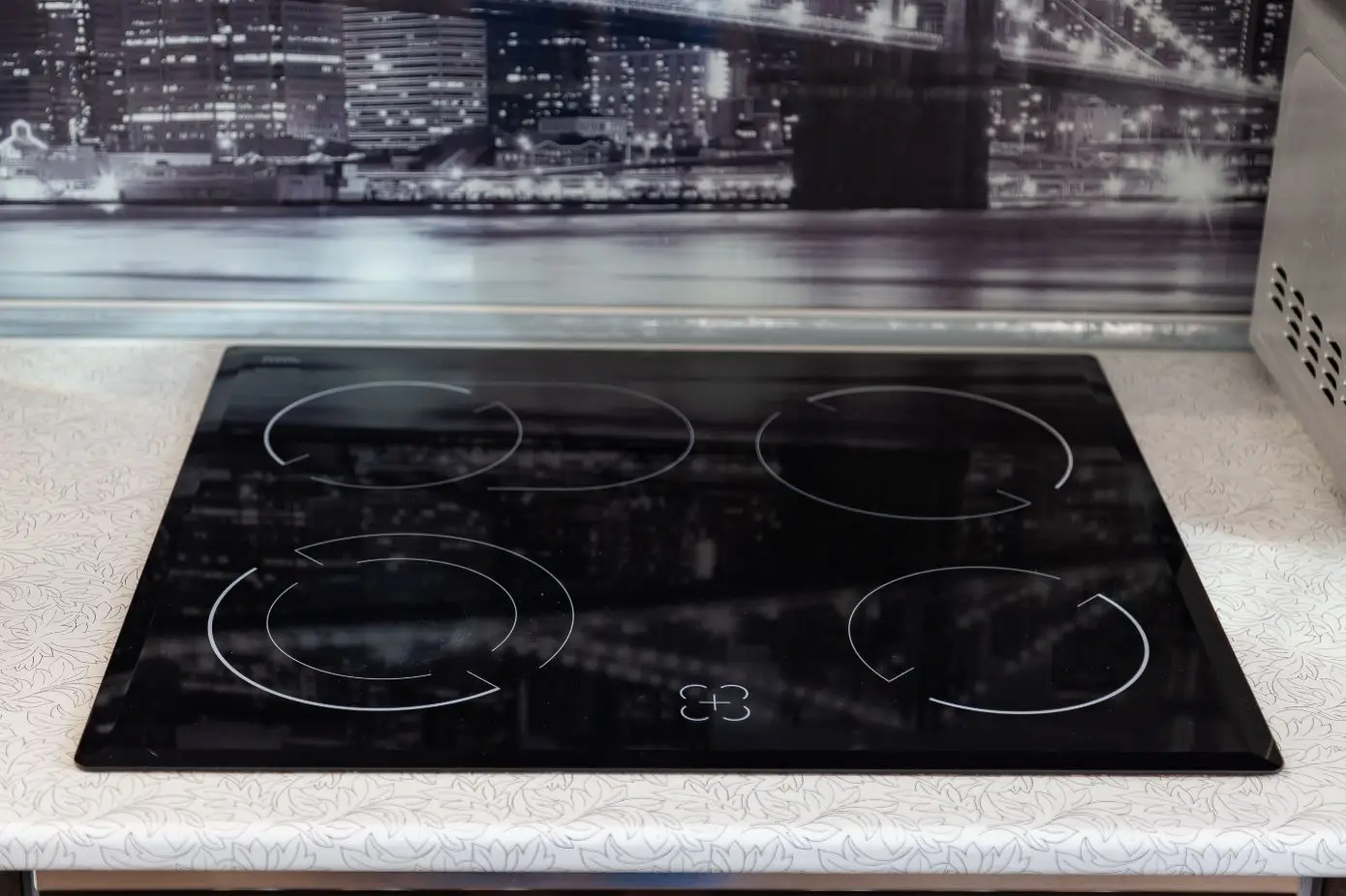 black four burner induction glass cooktop on a white counter