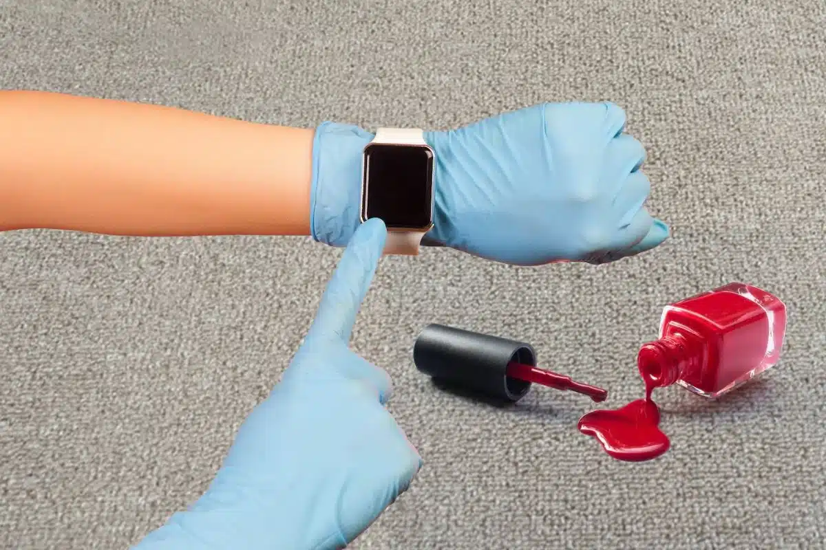 cleaner pointing to their watch after red nail polish has spilt on carpet
