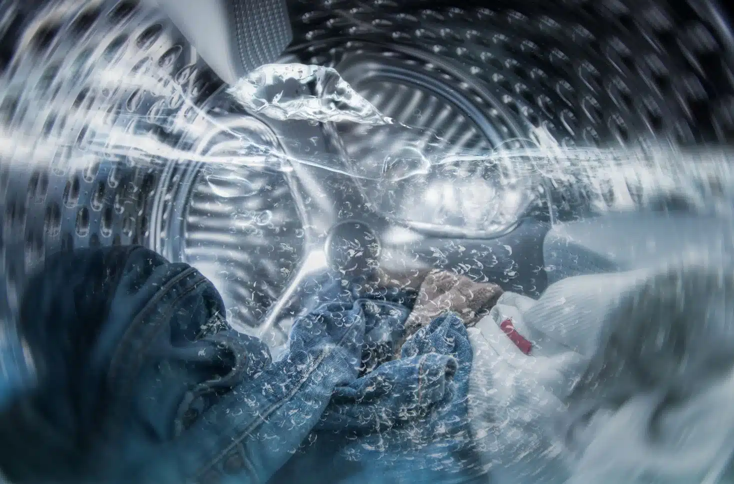 close up of jeans being washed in a half full front loader washing machine