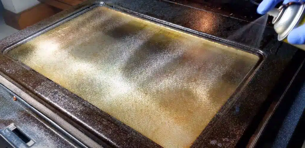 Heavily soiled oven being cleaned with easy off bam oven cleaner