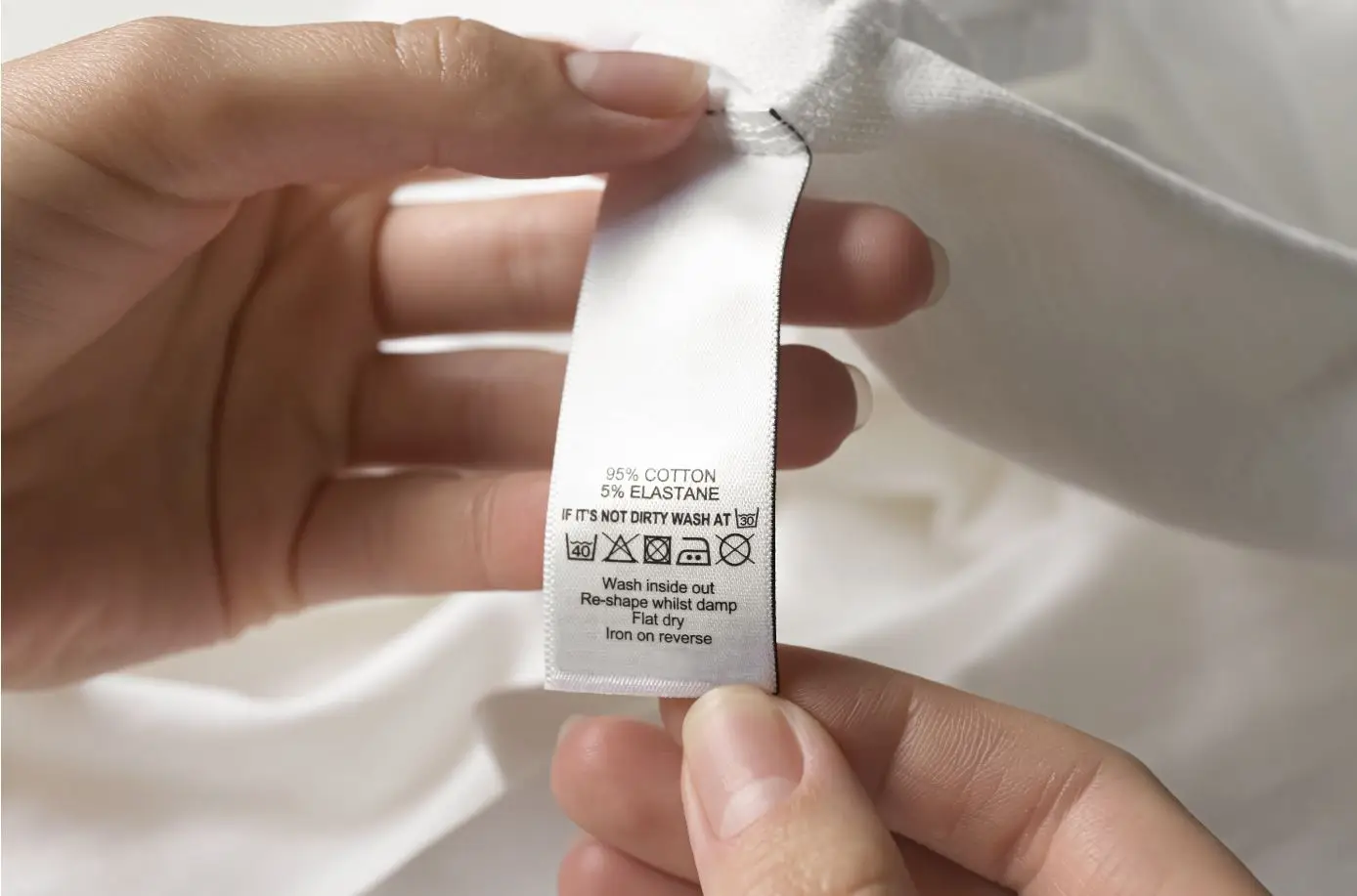 lady looking at the tag of a white shirt