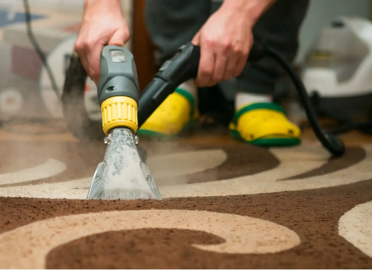 man using machine to shampoo carpets