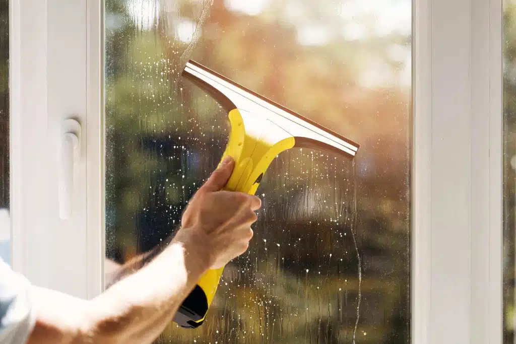 Man cleaning window with squeegee