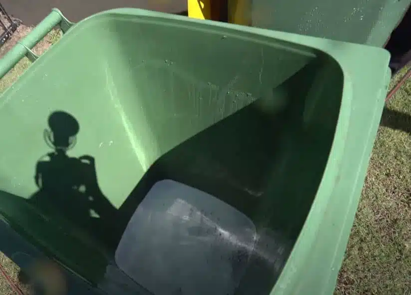 the inside of a green wheelie bin filled a quarter way with soap suds