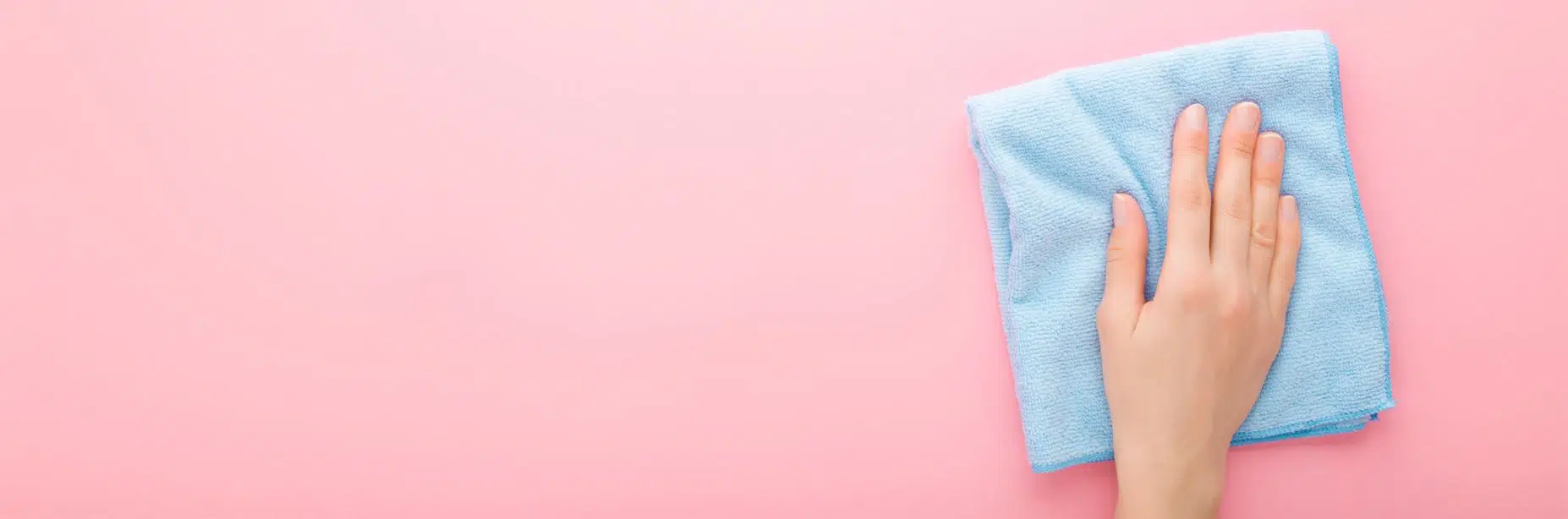 woman wiping down pink wall with a blue cloth