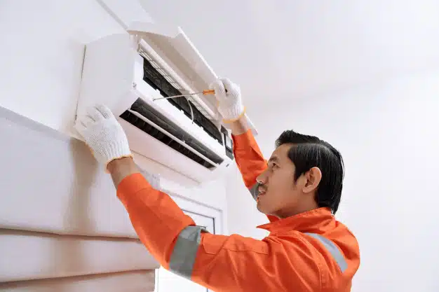 Male technician repairing air conditioner